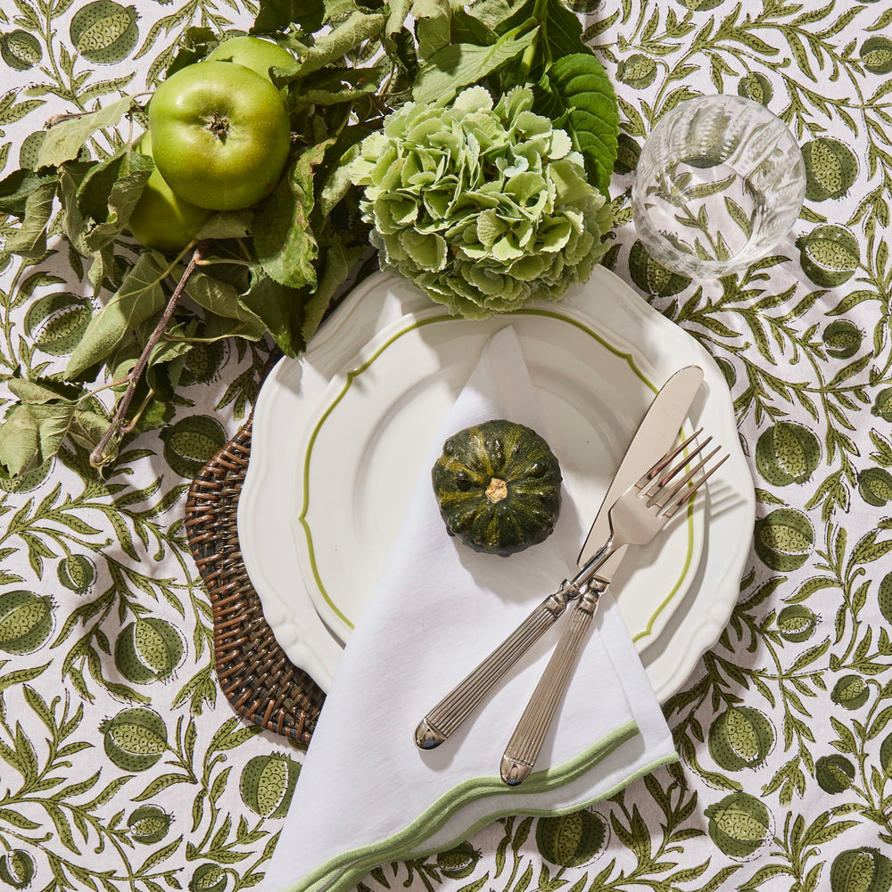Green scallop linen napkin showing embroidered edge detail
